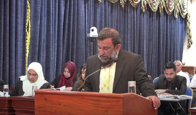 Abdulla Shairu speaking at a podium